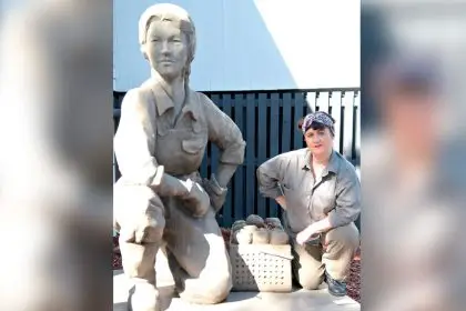 PAYING HOMAGE: Sharon Vassalo playing Bobby with a statue at the Birkdale Hall commemorating the work of the local Land Army. PHOTO: GREG POPE
