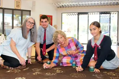 COLLABORATION: Artist Tania Budd and Sonja Carmichael add their drawings to the story cloth alongside Carmel College students. Photo: Jordan Crick