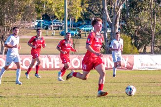 ON THE CHARGE: Redlands United’s man of the match Jack Skinner sets the Red Devils into attack. Photo: Ray Gardner