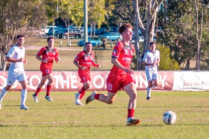 ON THE CHARGE: Redlands United’s man of the match Jack Skinner sets the Red Devils into attack. Photo: Ray Gardner