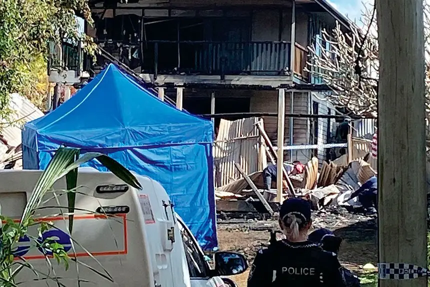 CHARRED: Police outside one of the homes damaged in the blaze. 