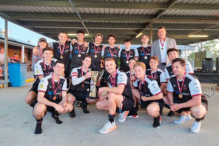 CHAMPIONS: The Redbacks’ Metro Men’s division eight side lift the trophy after defeating Logan Lightning 2-1.