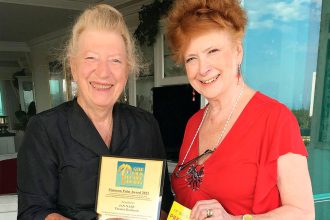 Playwright Jan Nary receives a Platinum Gold Palm award for writing The Other Diggers from Gold Palm awards actor/producer Kate Peters.
