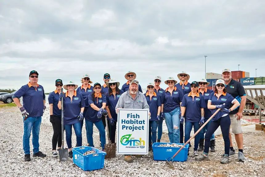Ozfish volunteers use a barge to transport cages of used oysters for deployment in the Bay
