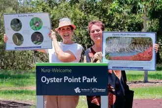 Local nature enthusiasts Vicki Salisbury (Ormiston) and Una Sandeman (Wellington Point) show temporary signs to highlight what to see along the Toondah Wetlands Discovery Trail.