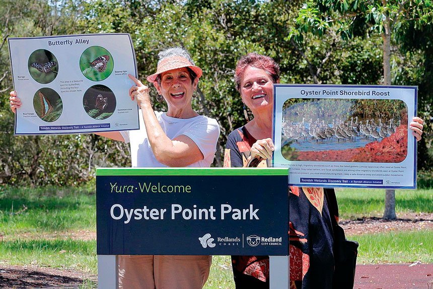Local nature enthusiasts Vicki Salisbury (Ormiston) and Una Sandeman (Wellington Point) show temporary signs to highlight what to see along the Toondah Wetlands Discovery Trail.