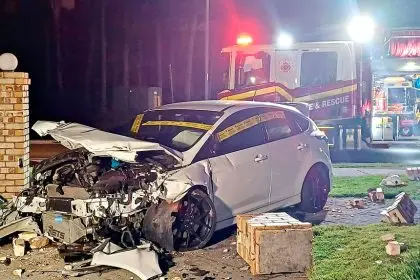 MAJOR DAMAGE: The wrecked car and fence after the crash.