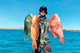 Fisherman Jimmy Atzeni with a black spot tusk fish, coral trout and red emperor.