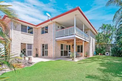 A covered deck flows onto a fully fenced, low-maintenance backyard.