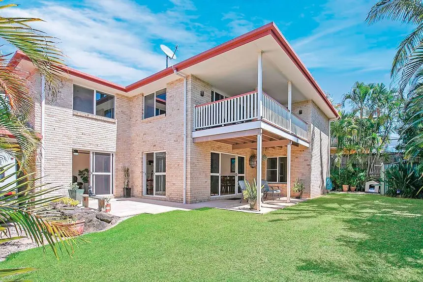 A covered deck flows onto a fully fenced, low-maintenance backyard.