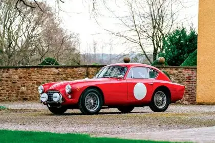 This meticulously restored 1957 AC Aceca-Bristo, finished in vivid red with white racing roundels, is being auctioned through RM Sotheby’s.