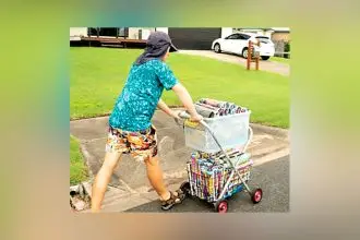 Joshua enjoys sorting the catalogues, rolling them, and loading up his delivery trolley.