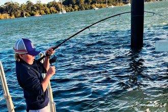 MAKING GRANDAD PROUD: Hugh Gordon reels in a large bream caught off the jetty of Lamb Island.