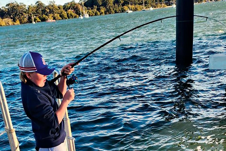 MAKING GRANDAD PROUD: Hugh Gordon reels in a large bream caught off the jetty of Lamb Island.